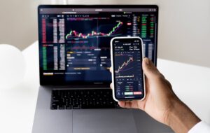 a man looking at stats on phone and laptop
